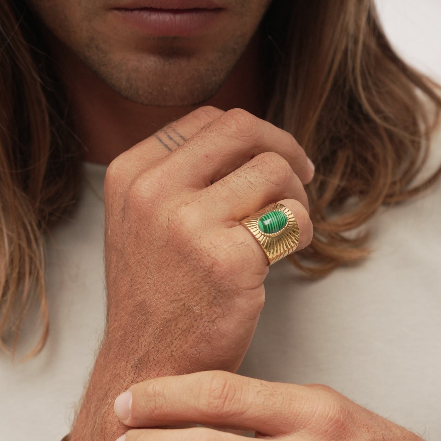 Anillo ancho de acero bañado en oro  18K con piedra ovalada de malaquita en el centro y diseño en forma de anillo con sol - Bendita Eva