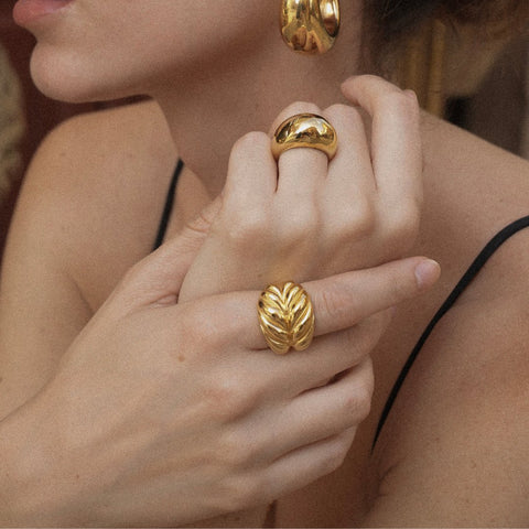 Anillos fabricados en plata de 925 o en acero inoxidable todos con un acabado de baño de oro de 18K