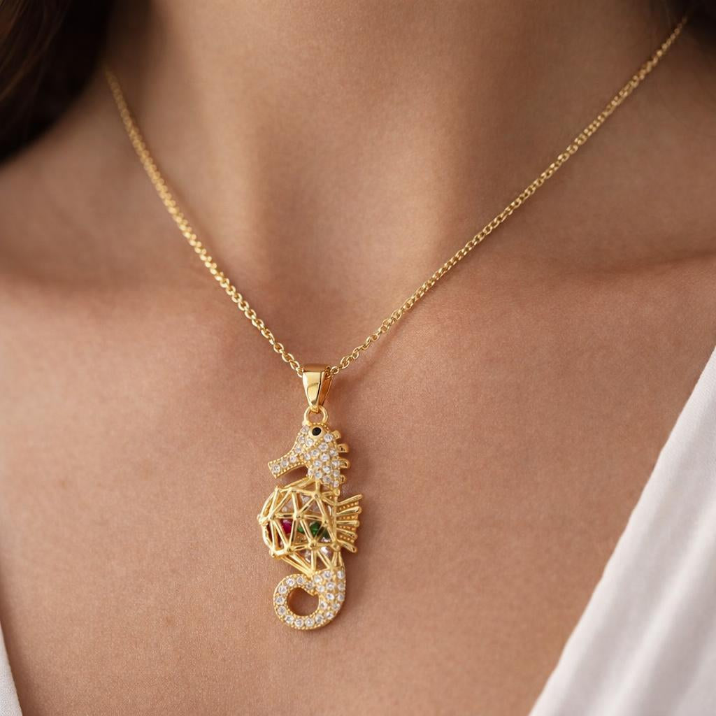 Colgante caballito de mar de Bendita Eva en plata de ley con baño de oro 18K, con circonitas y lucido en modelo. Amuleto artesanal de 34 mm que aporta protección, paciencia y buena suerte, versátil y elegante para el día a día.