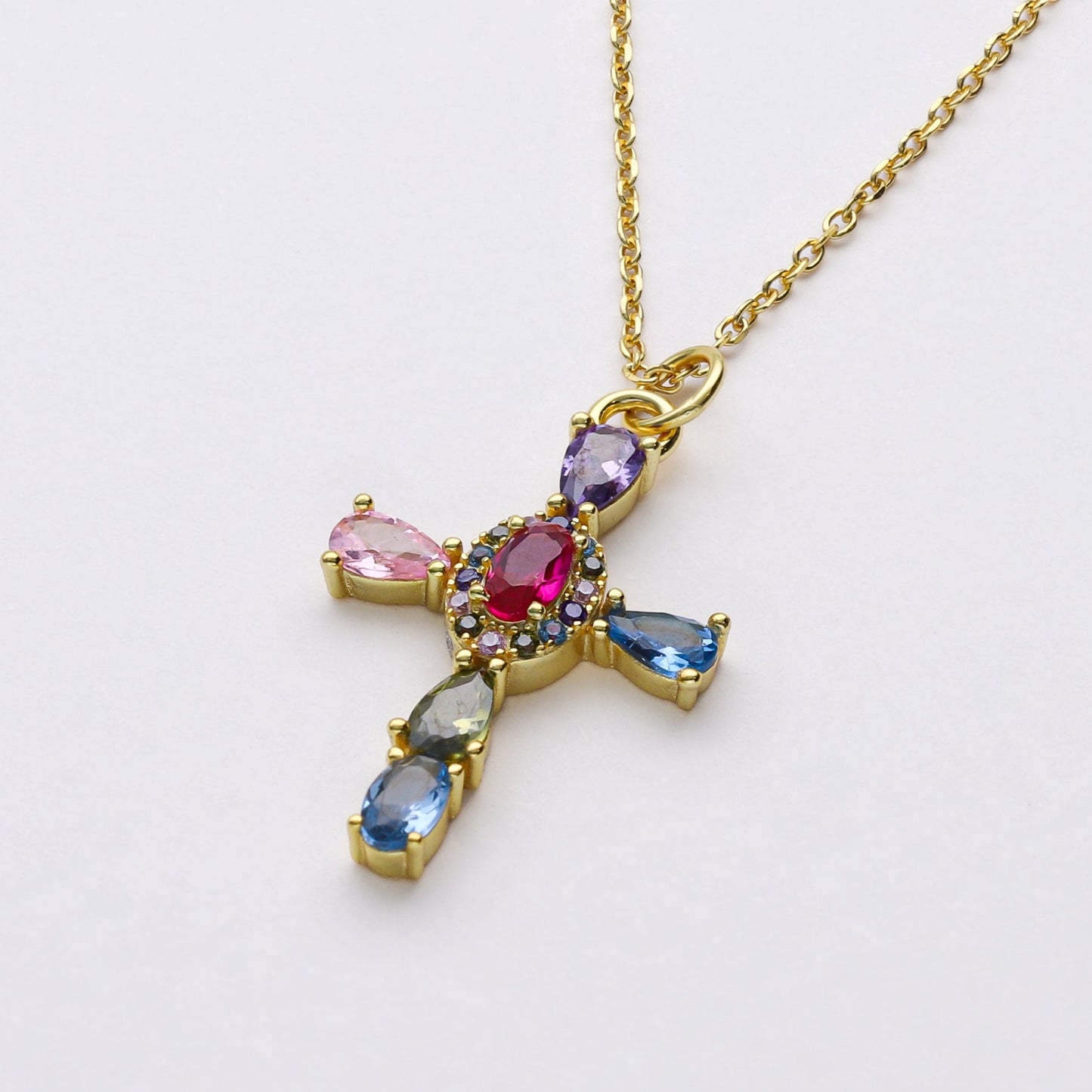 Primer plano del Colgante Cruz Multicolor de plata de ley 925 y baño de oro 18kt, con piedras multicolor engarzadas a mano, joya artesanal única - Bendita Eva
