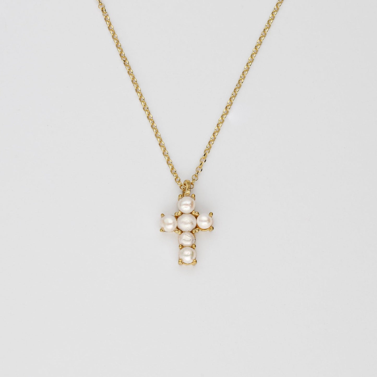 Colgante cruz con perlas naturales Bendita Eva, plano general con cadena, elegante y atemporal.