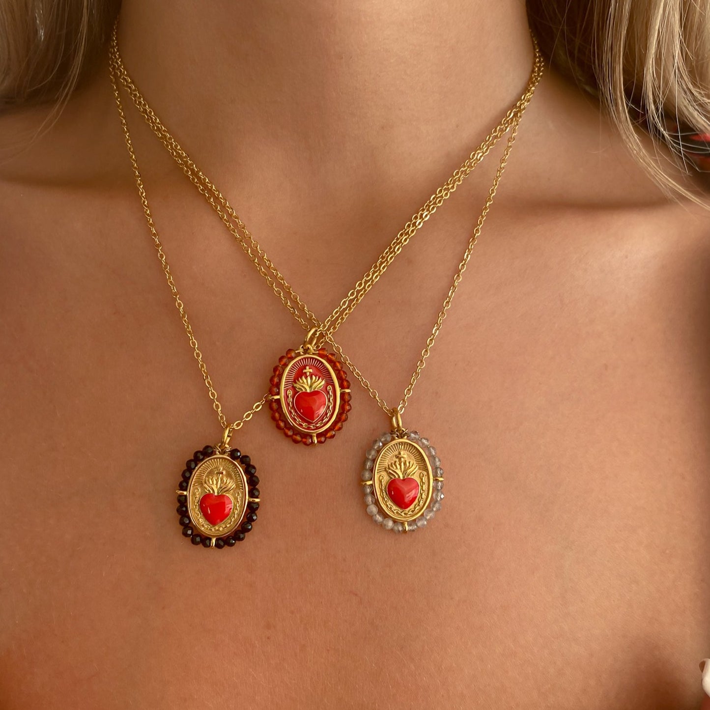 Colgante Sagrado Corazón Ónix de Bendita Eva lucido en modelo en layering con otros colgantes, mostrando diseño artesanal y piedras de ónix protector.
