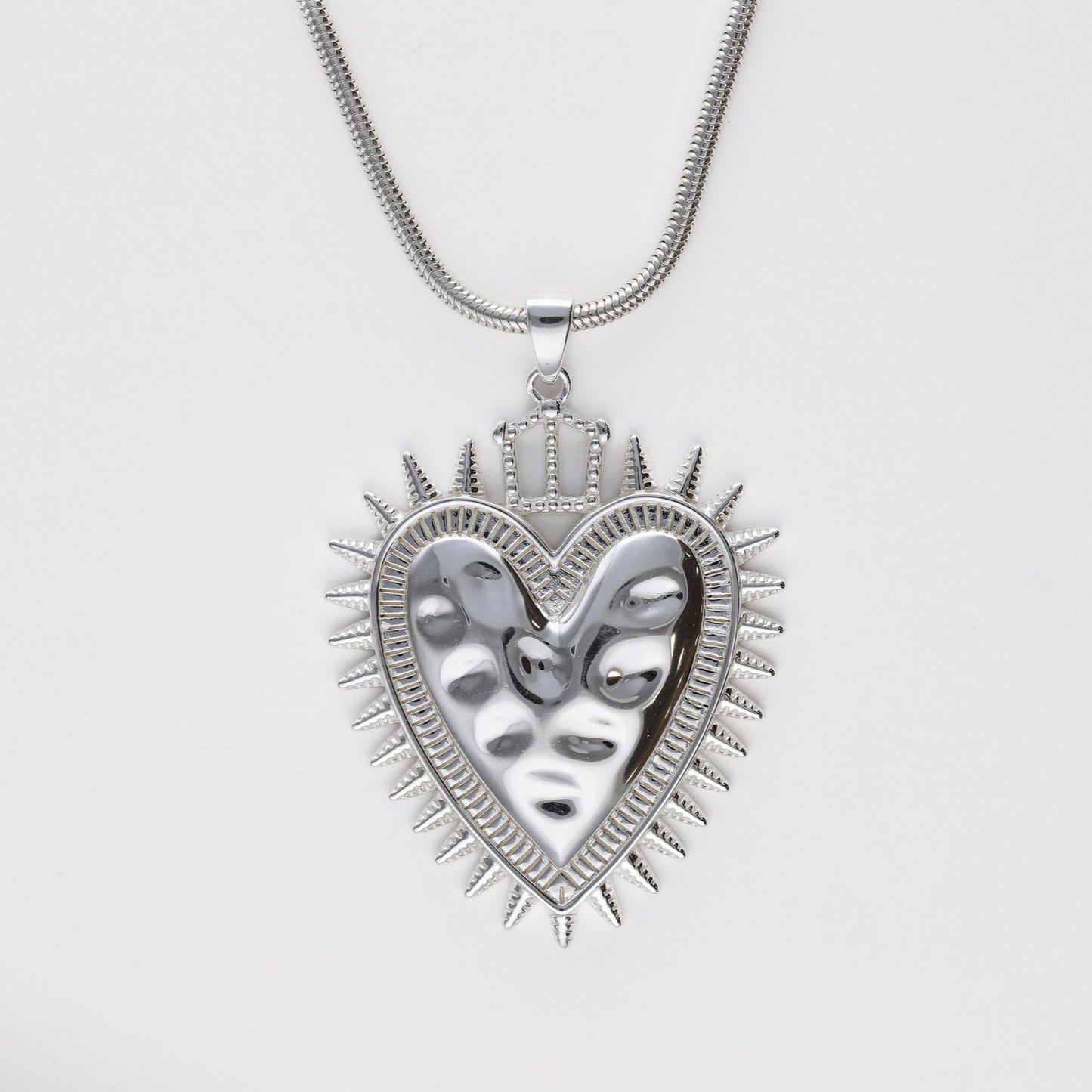 Colgante Sagrado Corazón Protection de Bendita Eva en plata de ley con baño de oro, mostrado en plano detalle con cadena, joya amuleto de diseño español.