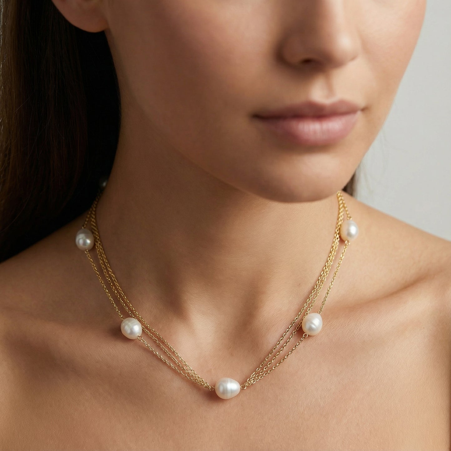 Collar de perlas naturales lucido sobre modelo, cadena triple de plata de ley bañada en oro 18K, joya artesanal española y elegante de Bendita Eva.