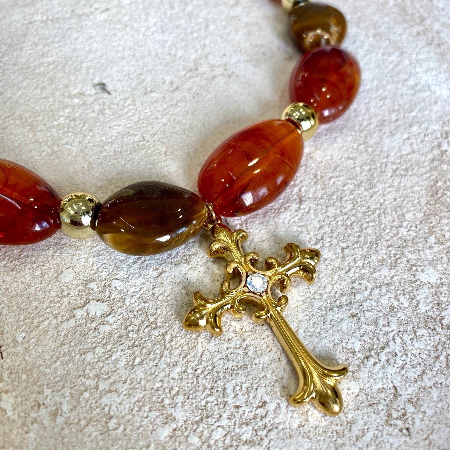 Detalle del colgante cruz del collar de piedras de Bendita Eva con acabado en oro de 18K