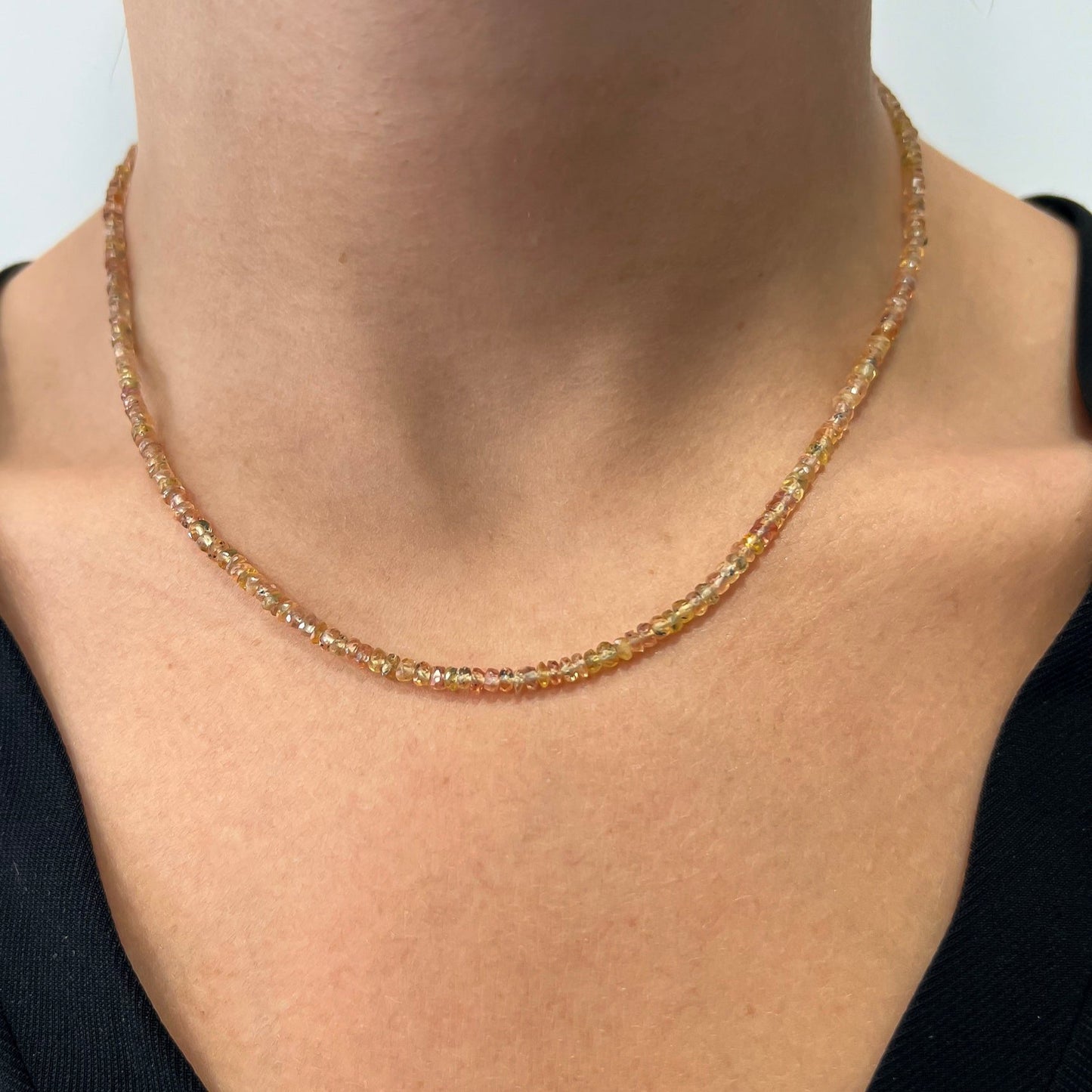 Collar de zafiro Padparadscha natural de Bendita Eva lucido en modelo, mostrando cómo se adapta elegantemente al cuello y resalta los colores vibrantes de los zafiros, reflejando la artesanía española y la exclusividad de cada pieza.
