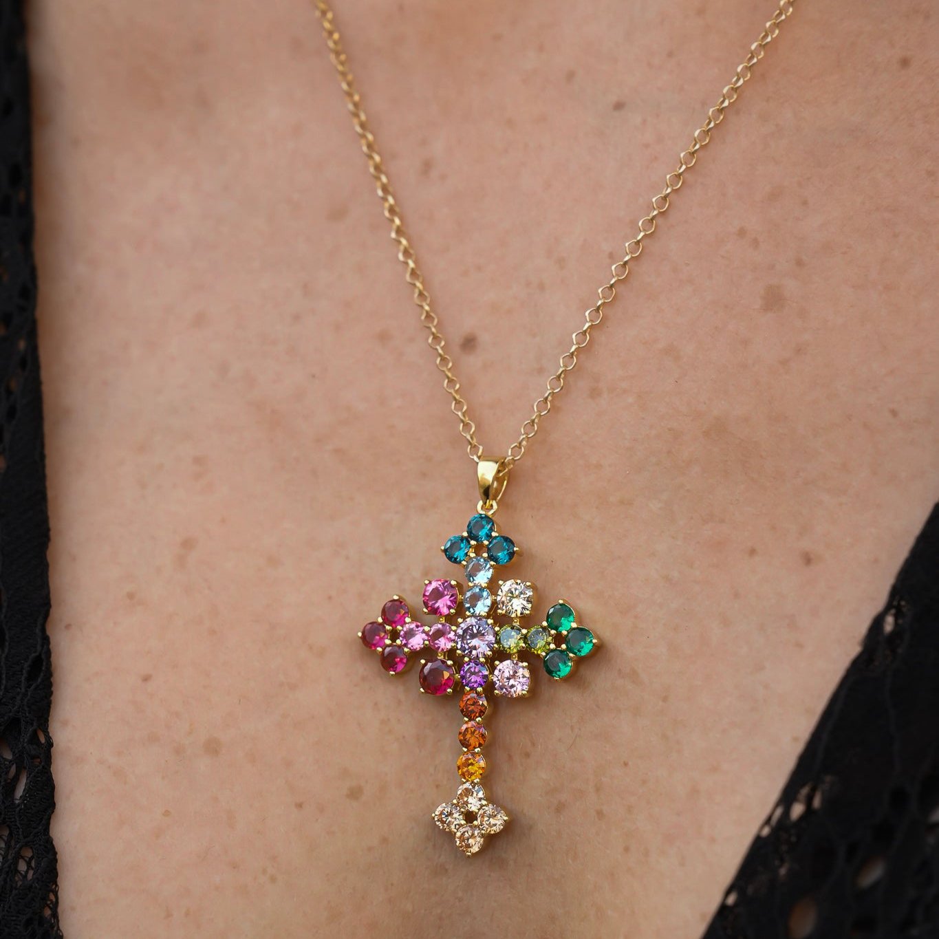 Cruz Victoria de 4 cm con piedras de colores lucida como colgante por una modelo, joya simbólica de Bendita Eva.