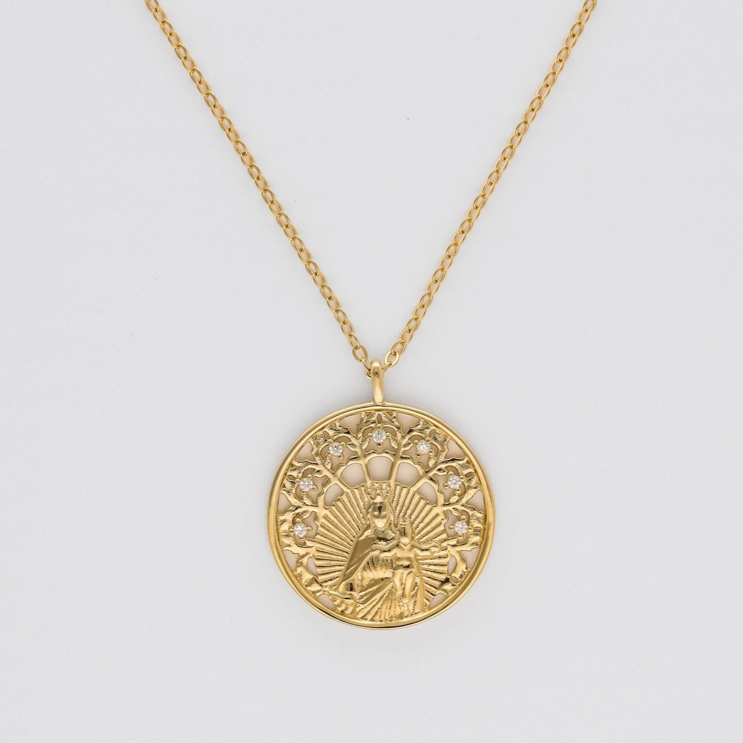 Detalle de las circonitas que adornan la medalla de la Virgen del Carmen en plata bañada en oro de 18K de Bendita Eva.