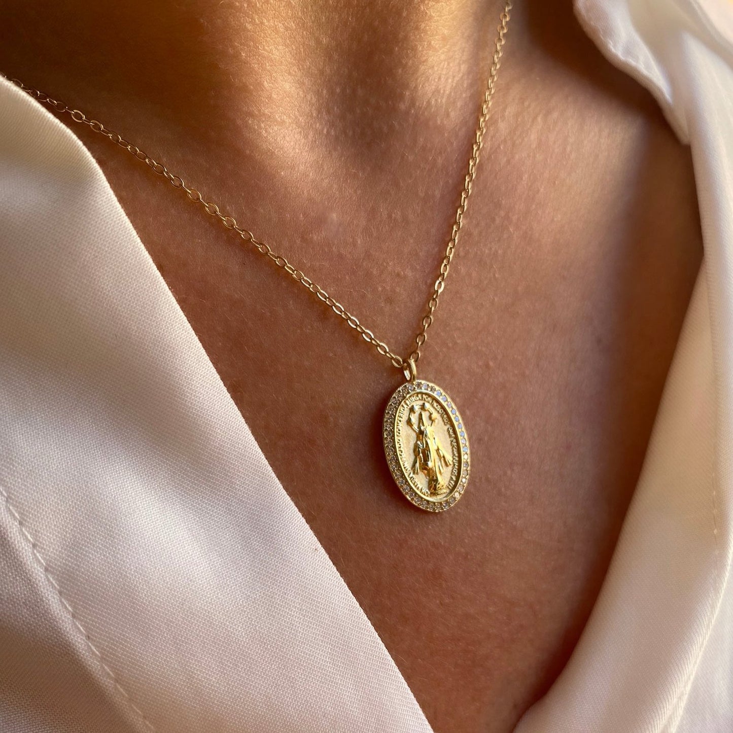 Medalla de la Virgen de la Milagrosa con circonitas lucida como colgante por una modelo, joya de Bendita Eva.