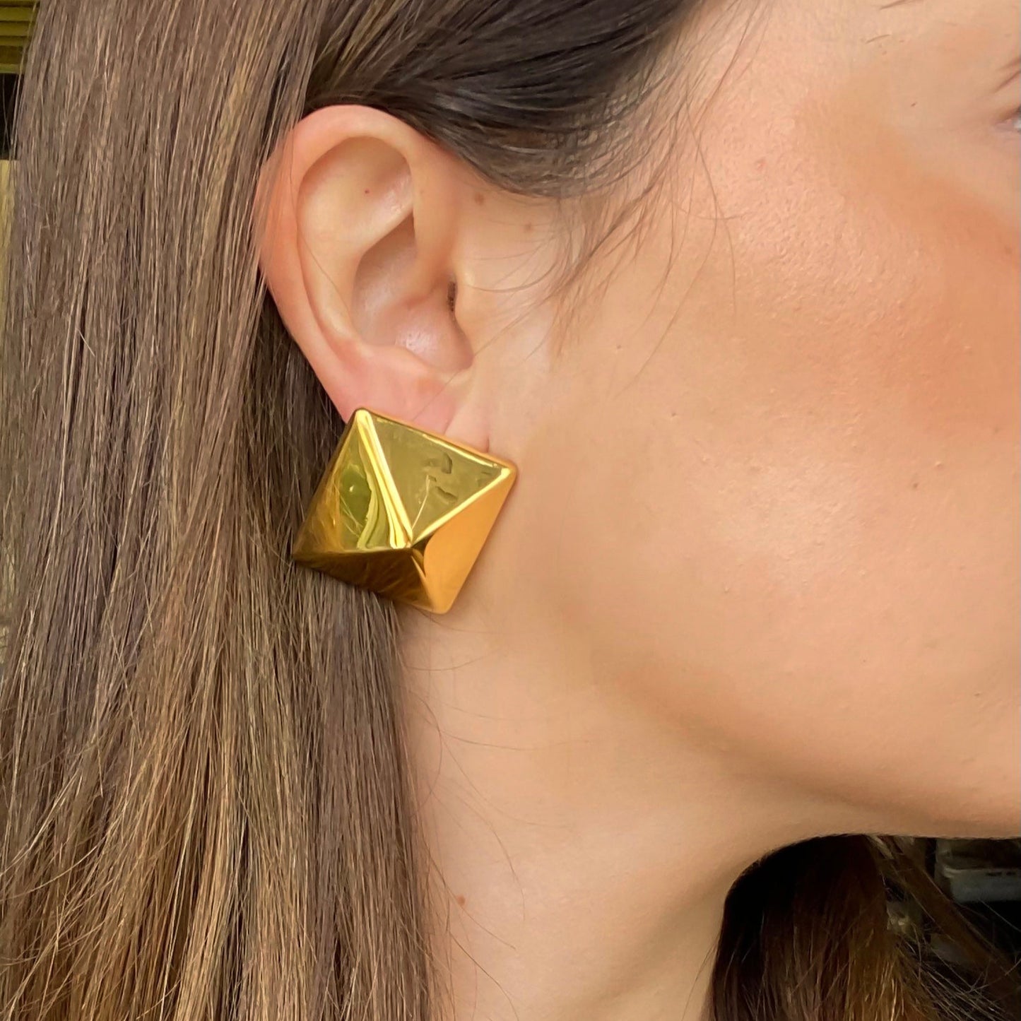 Pendientes XL Pirámide de Bendita Eva en acero hipoalergénico bañados en oro 18K, lucidos sobre modelo 