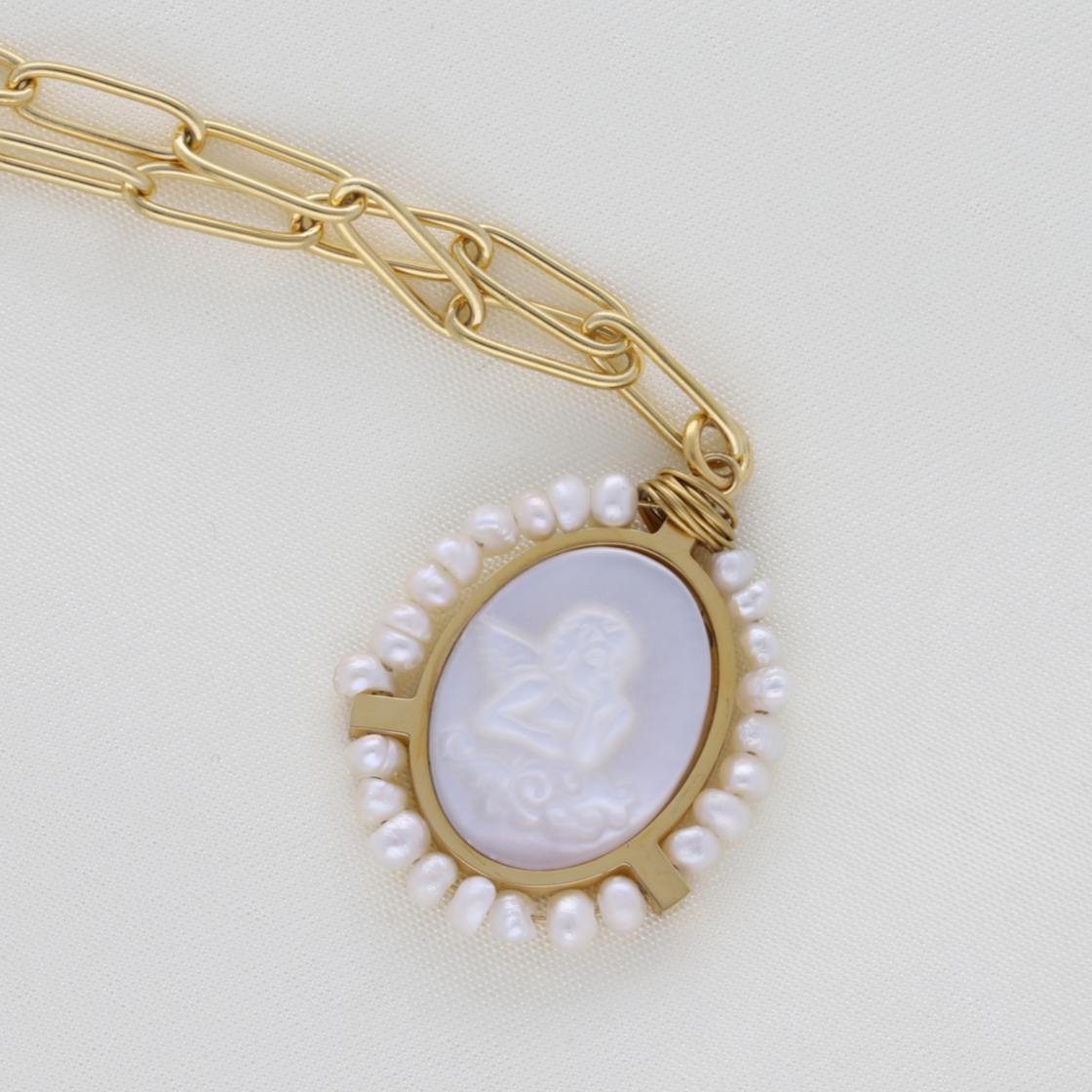 Su medalla nacarada con un ángel grabado y rodeado de perlas naturales , hacen de este colgante de 23 mm una joya especial y única. Su cadena mide 55 cm. Esta pieza es resistente al agua , 100% reciclable , hipoalergénica , de fácil mantenimiento , duradera y muy resistente.