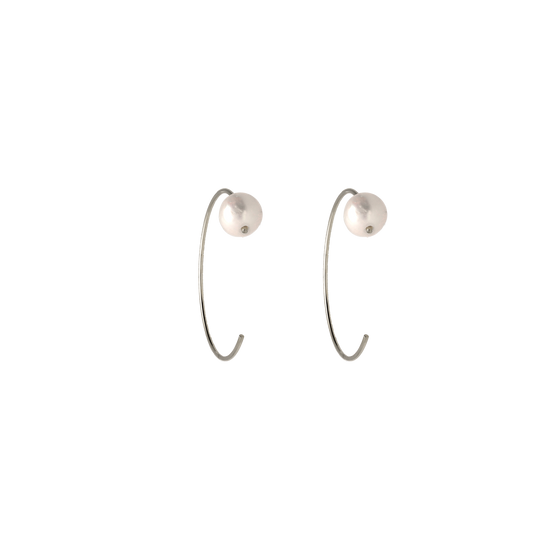 Pendientes finos, abiertos con una perla en el borde. La perla, como elemento principal de esta joya, transmite elegancia y sensualidad. 